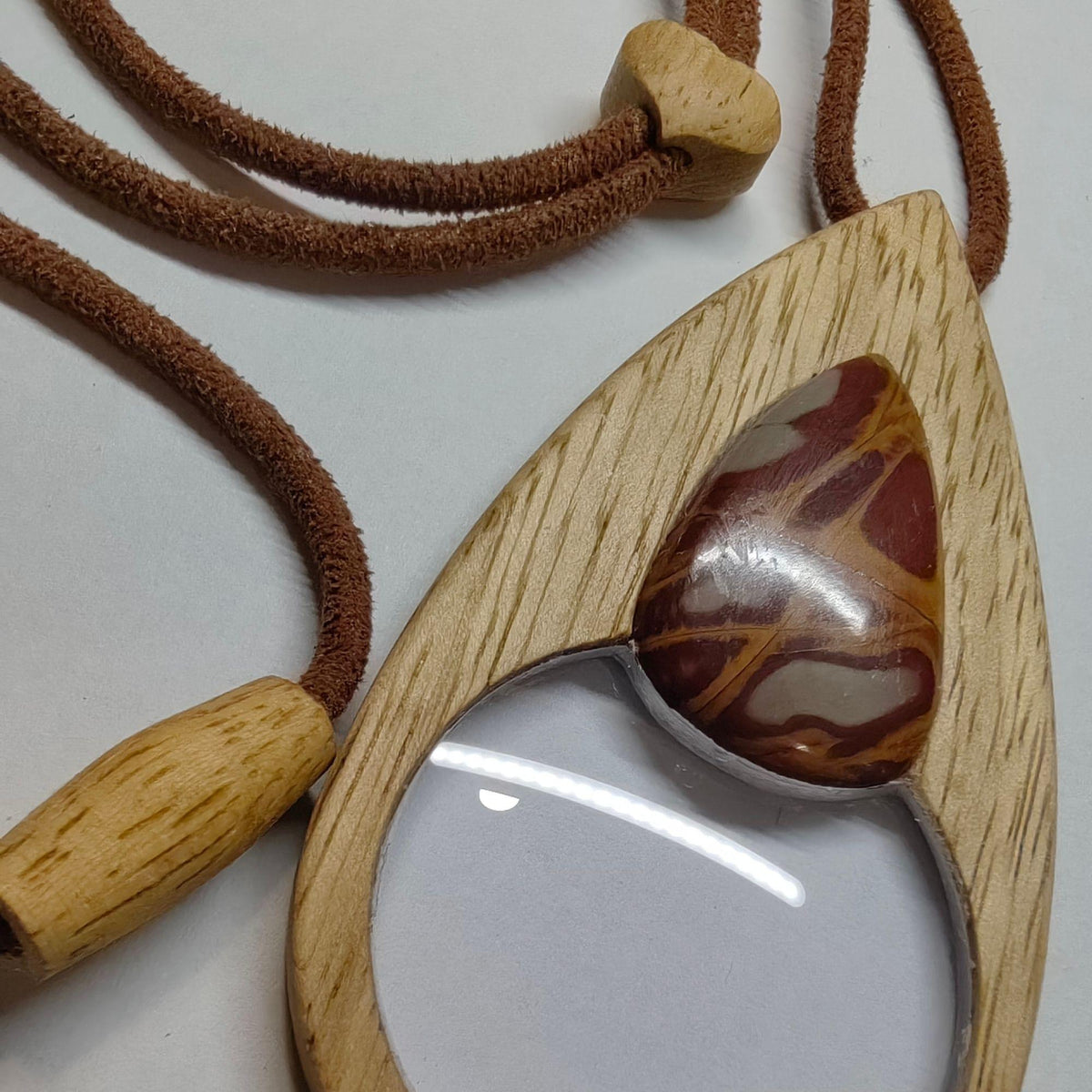 An elegant magnifying glass necklace where beech wood and Noreena Jasper come together.